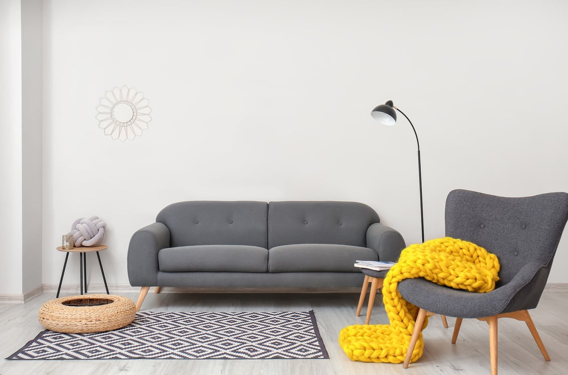 Interior of Modern Room with Sofa, Armchair and Knitted Plaid